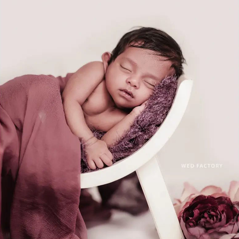 a baby sleeping on a small chair