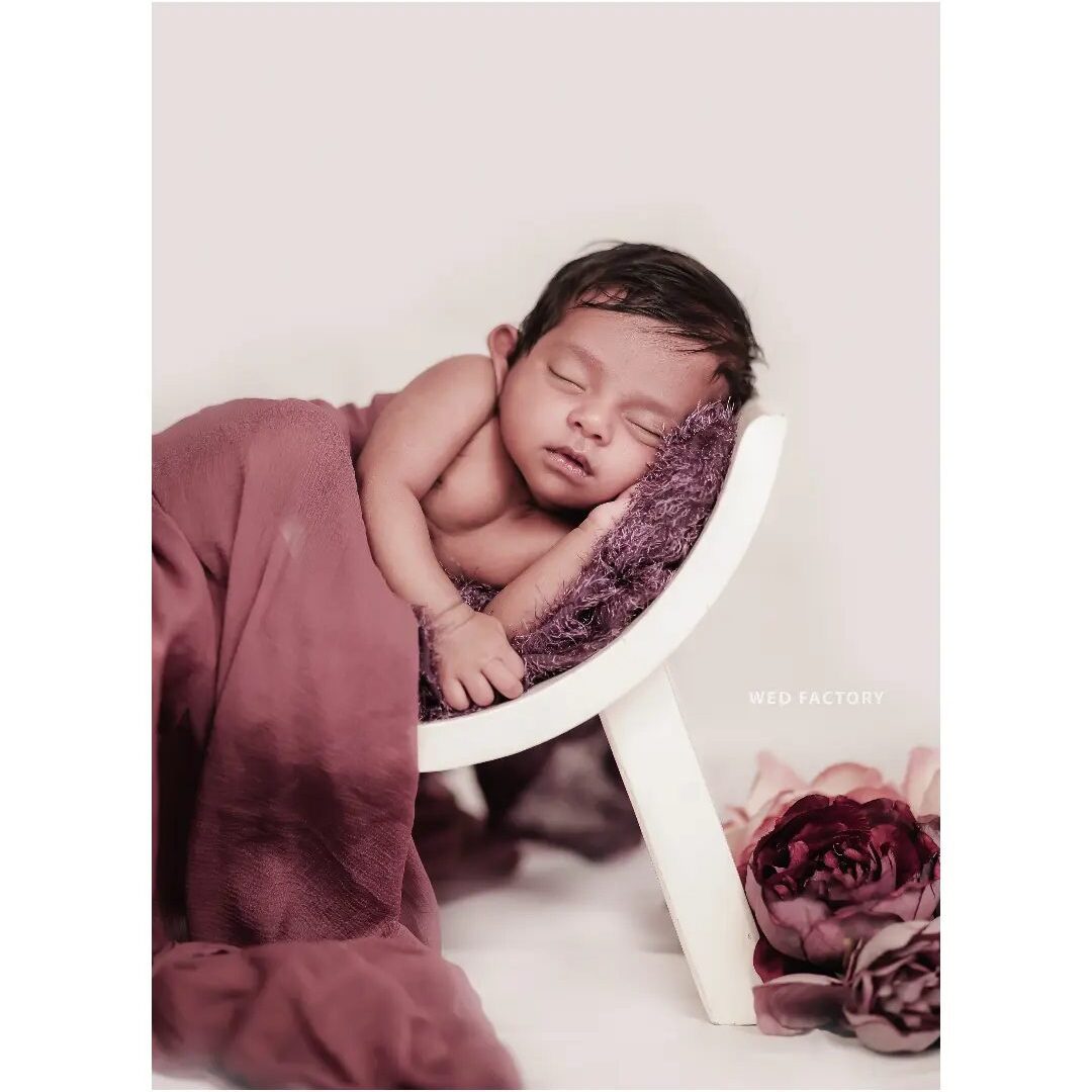a baby sleeping on a small chair